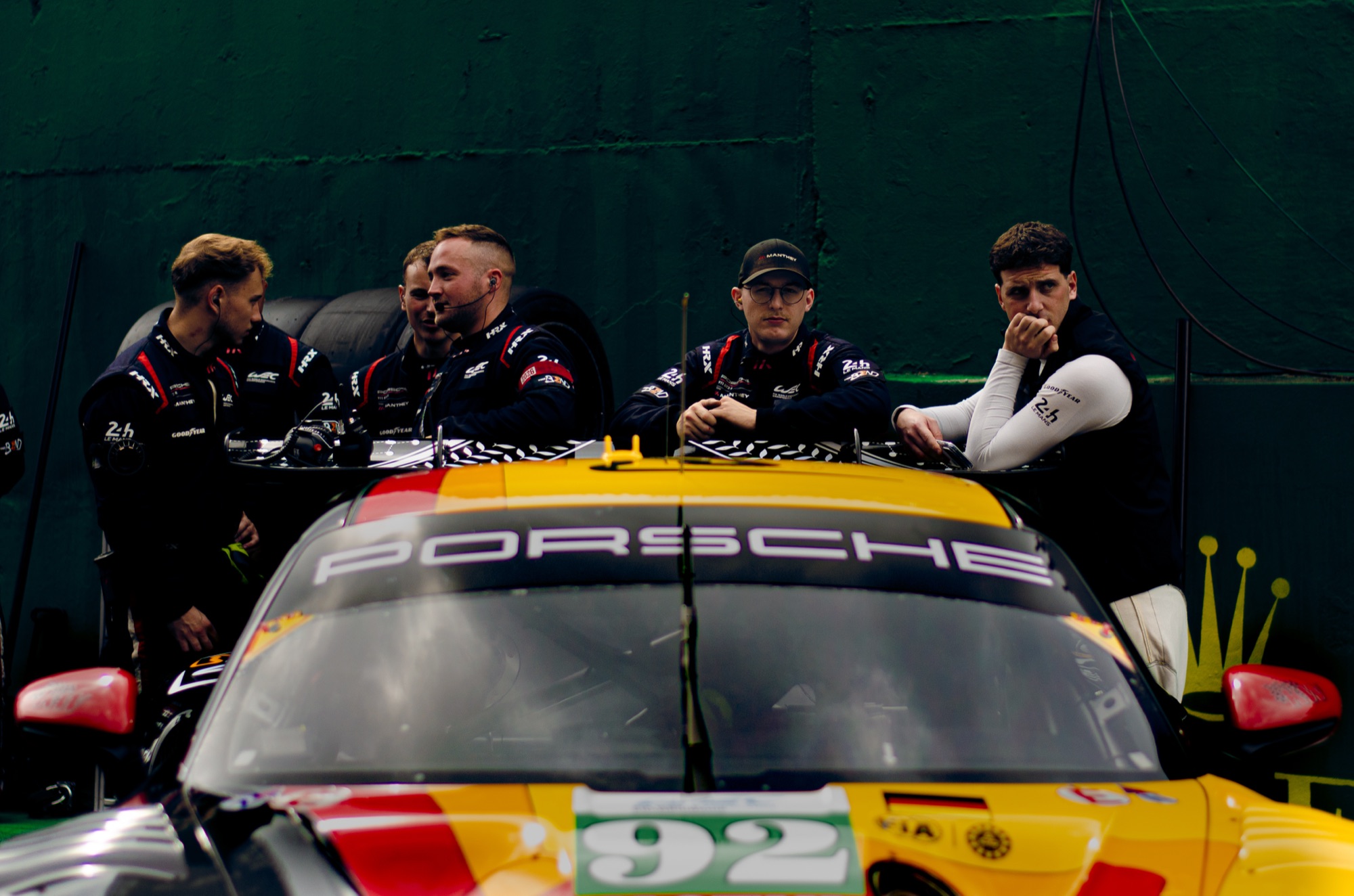 Equipe da Manthey debruçada sobre o teto do Porsche 911 GT3 R #92, esperando nos boxes