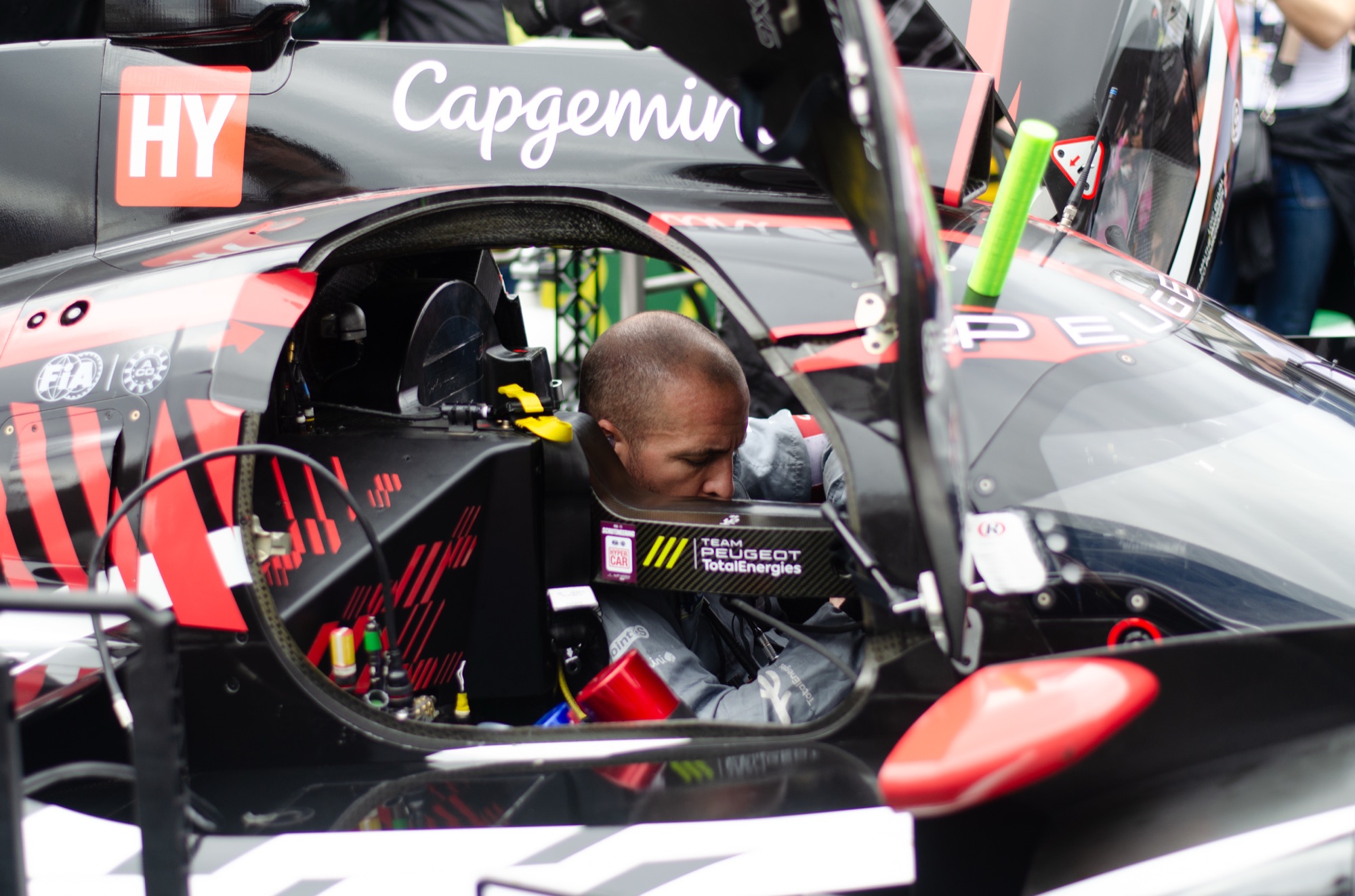 Mecânico debruçado no cockpit do Peugeot 9X8 da Team Peugeot TotalEnergies