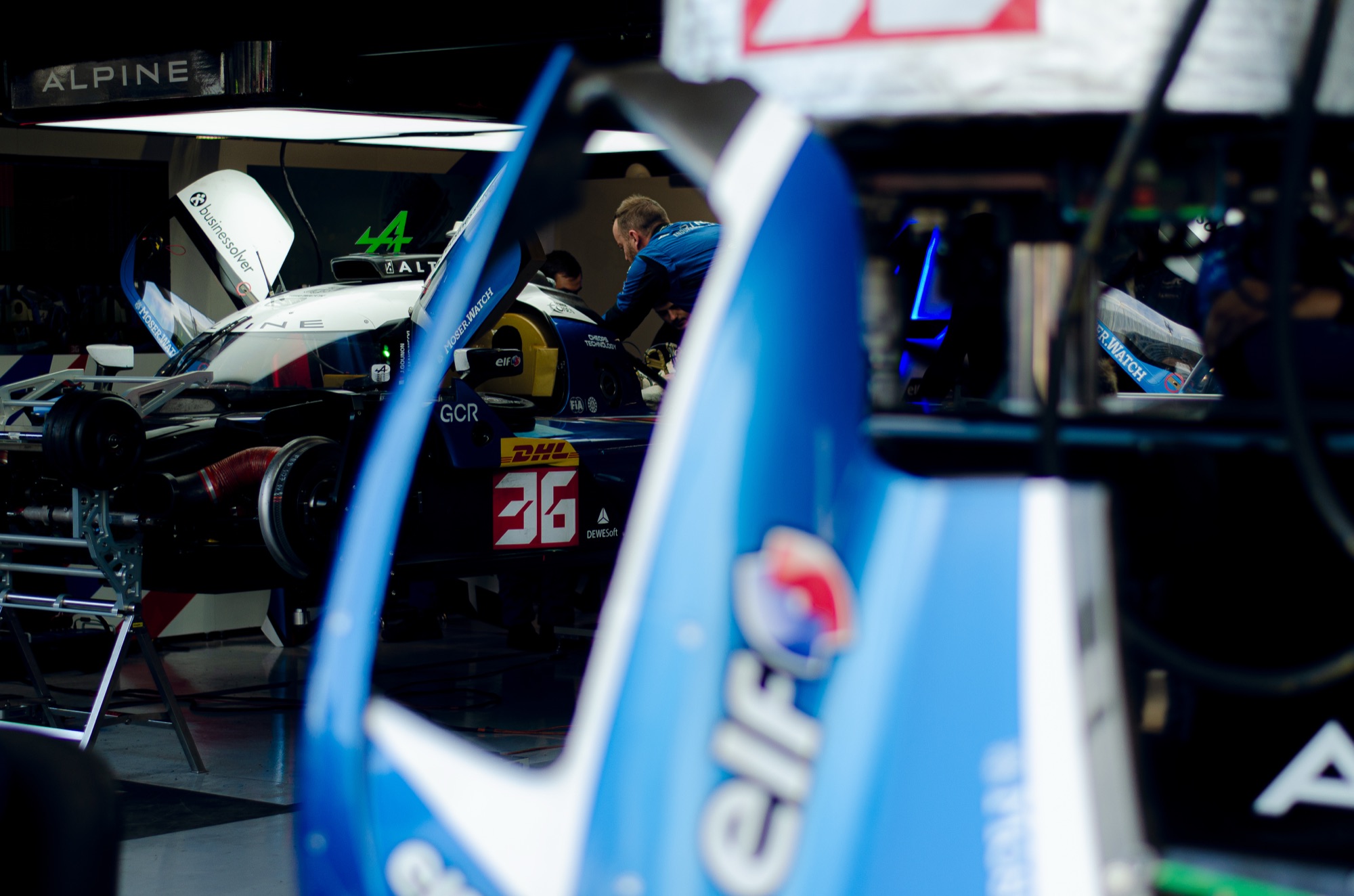 Alpine A424 #36 na garagem, enquadrado por uma carenagem azul com o logo elf em primeiro plano
