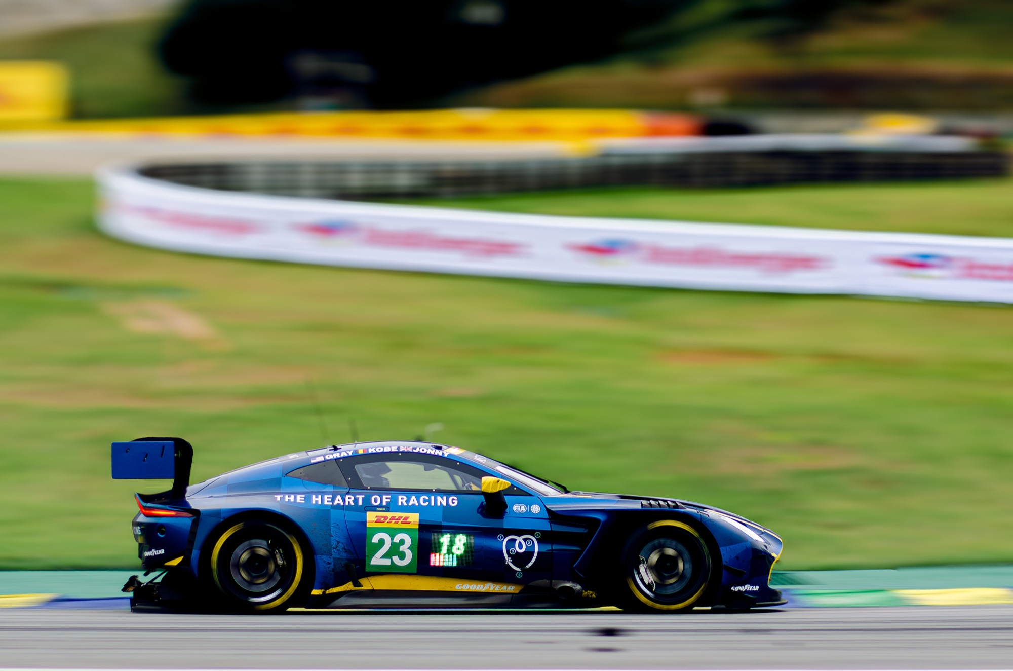 Aston Martin Vantage GT3 #23 da The Heart of Racing em panning, com o gramado varrido ao fundo