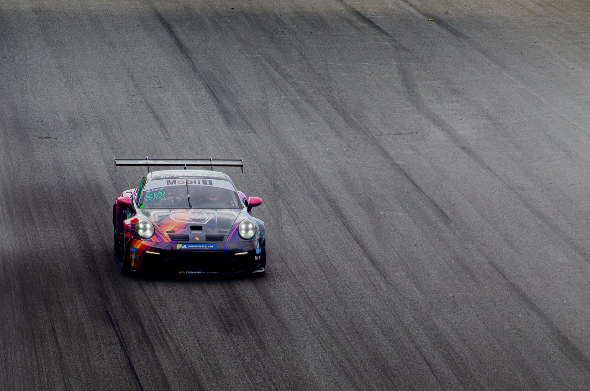 Porsche 911 GT3 Cup #32 de M. Roque de frente, sozinho na extensão cinza do asfalto